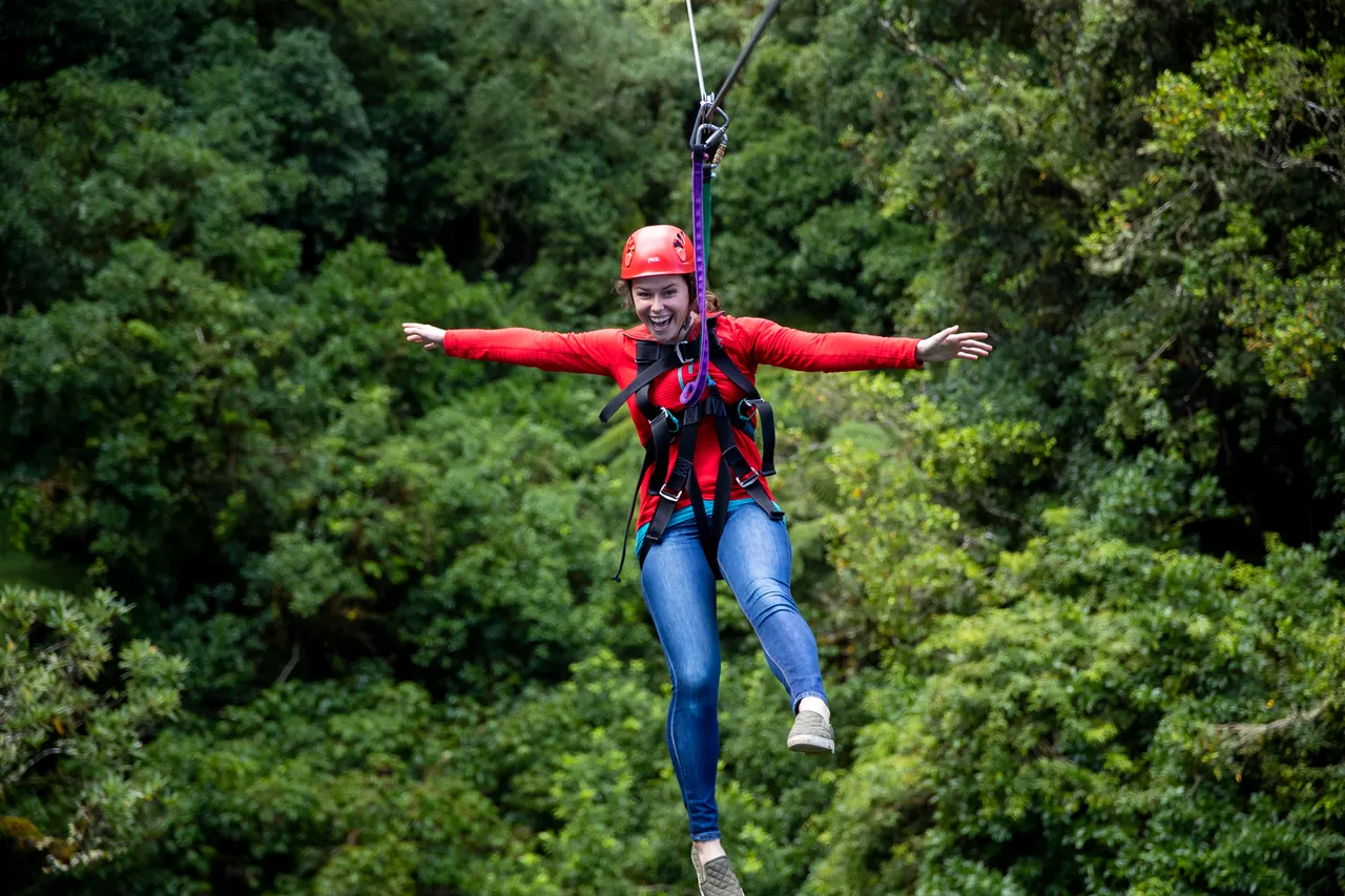 rotorua-canopy-tours-original-ziplining-woman-arms-out