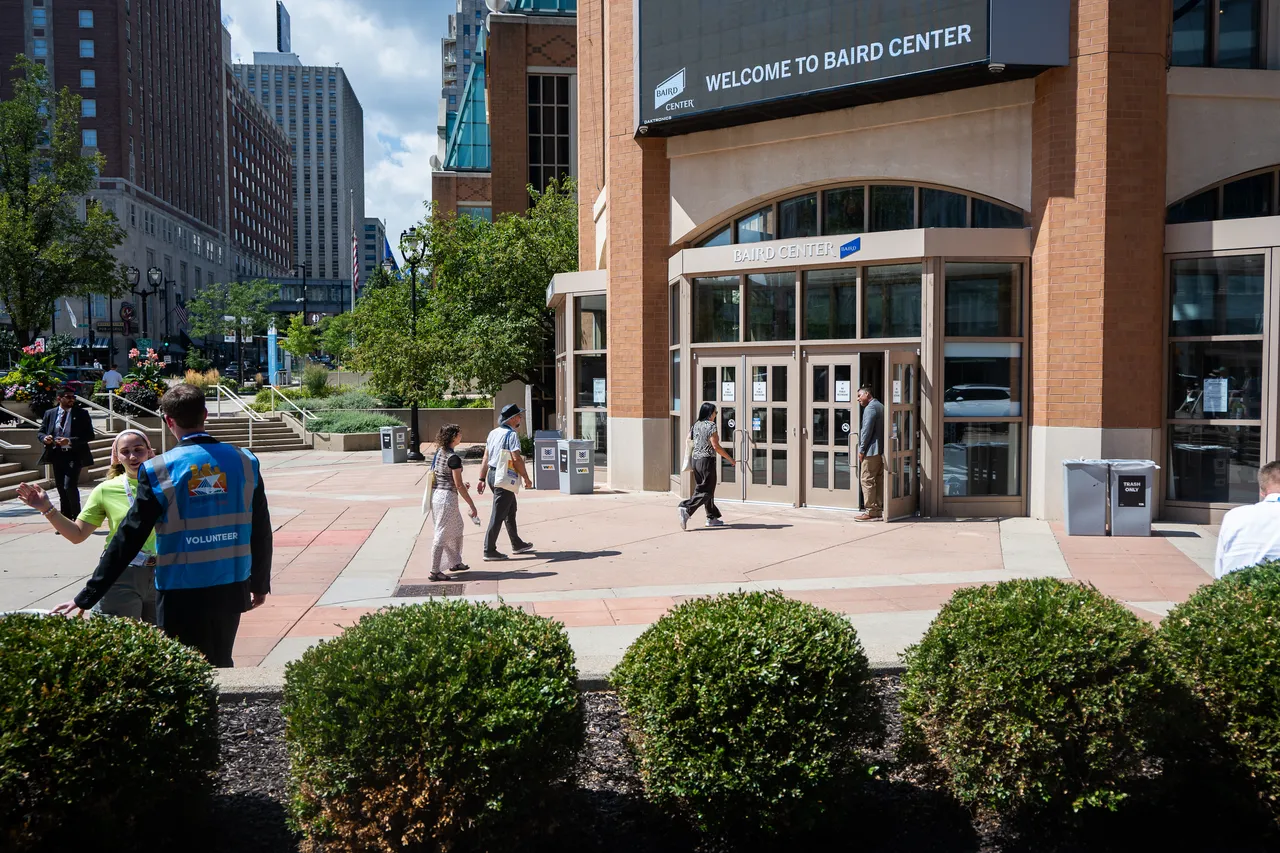 Visitors and volunteers walk outside the Baird Center entrance in downtown Milwaukee.