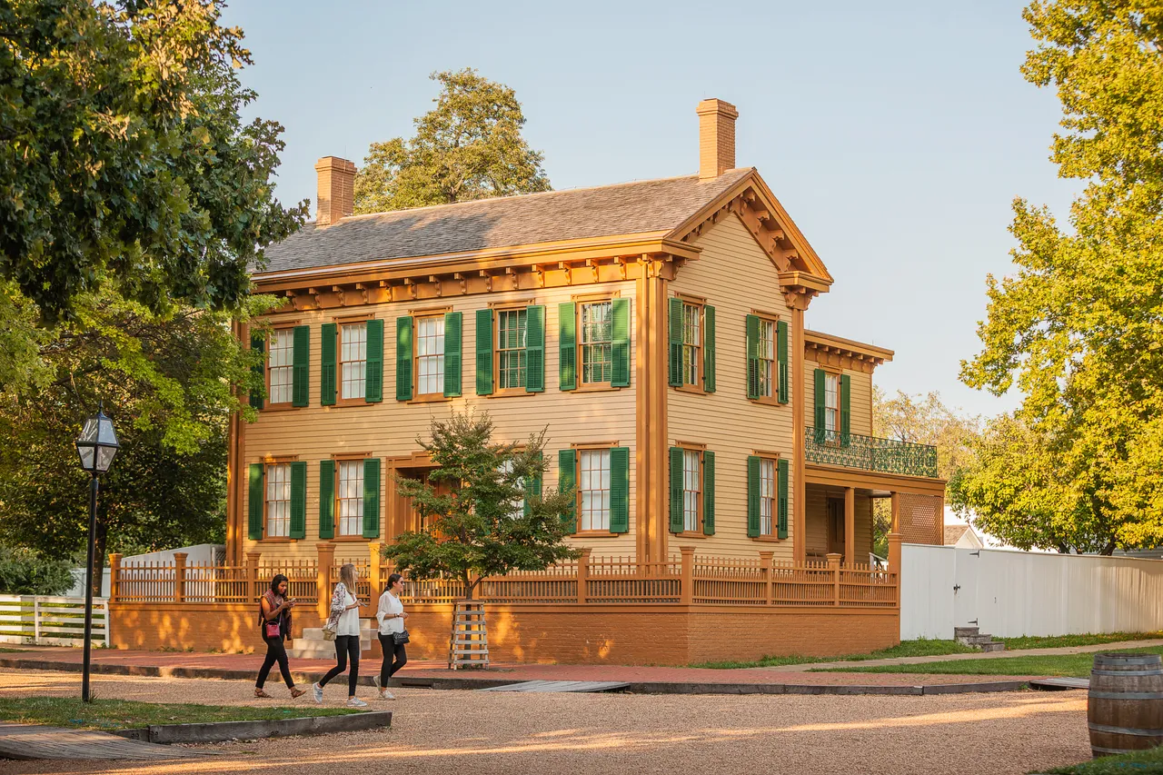 Wide shot of group of women walking in front of the Lincoln Home in Springfield