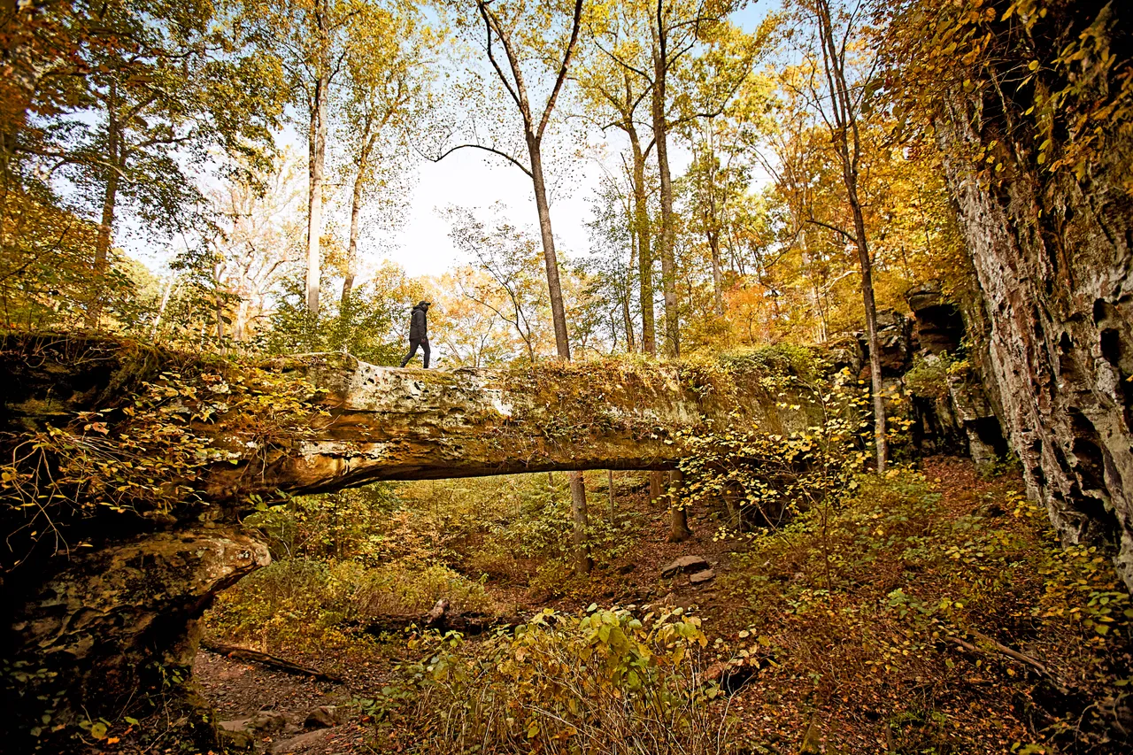 Person walking across Pomona natural bridge in the Shawnee National Forest