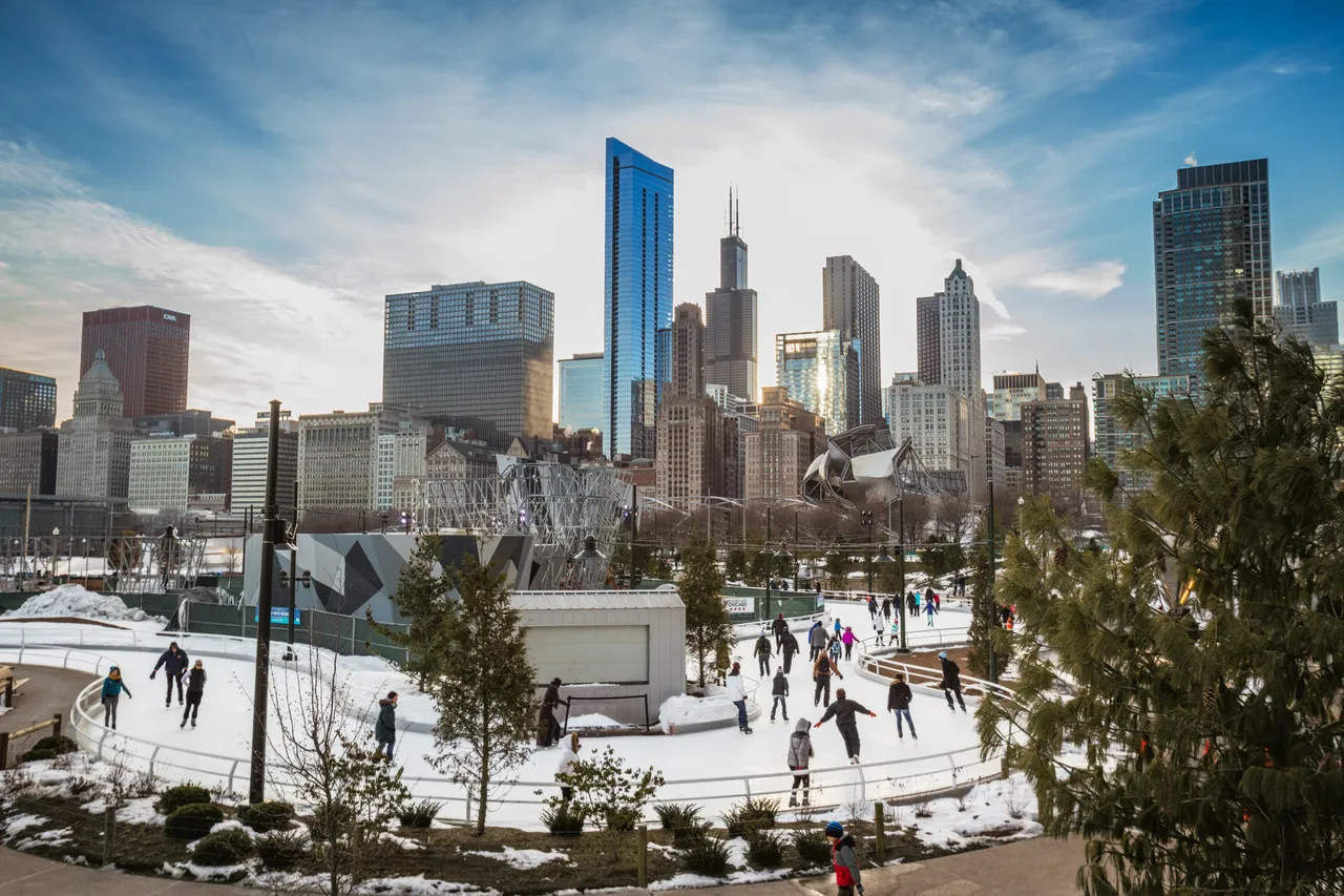 Wide shot of Chicago skyline in winter and Maggie Daley Park Ice Skating Ribbon