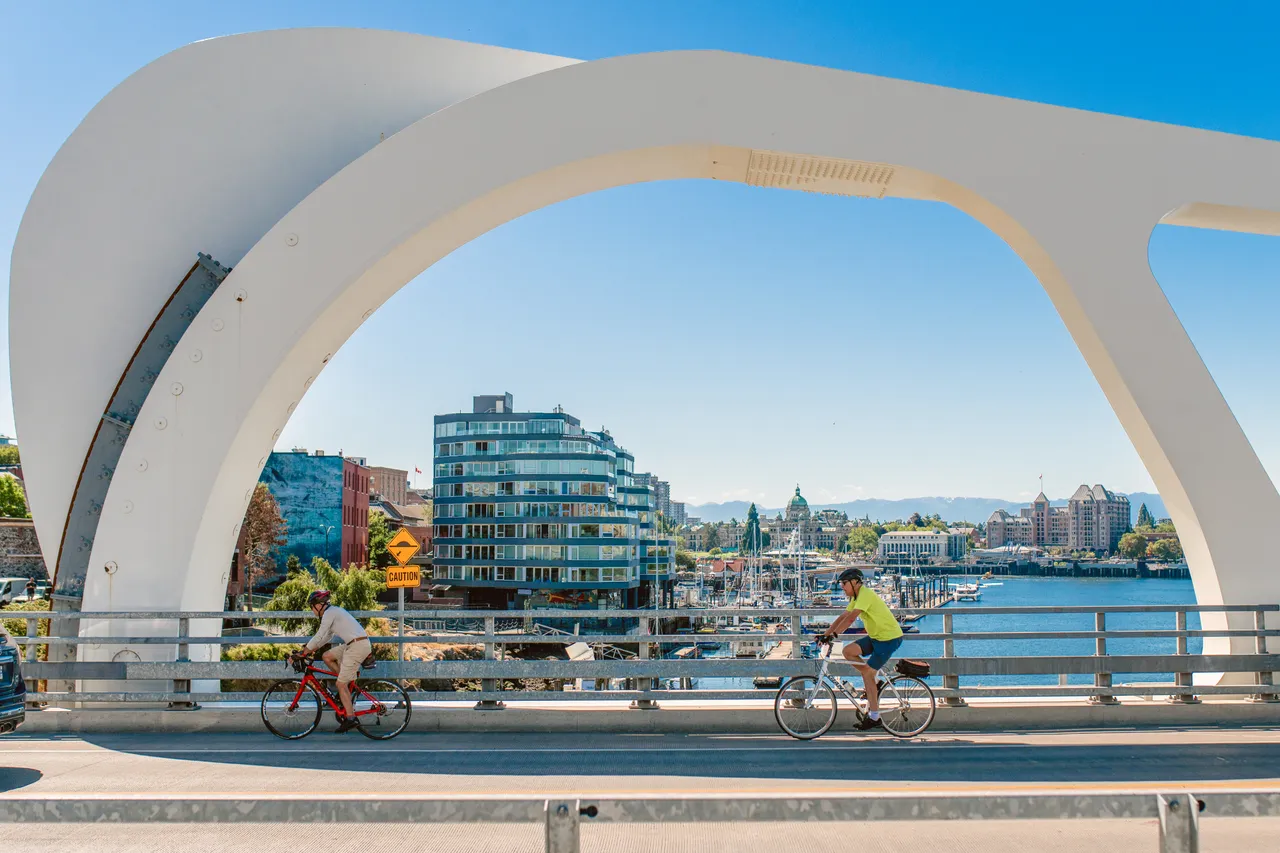 Men cycling across bridge - 1 - Victoria