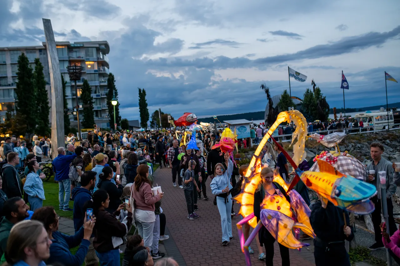 Illuminated Sea Creature Lanterns Move Through Crowd at Waterfront Parade