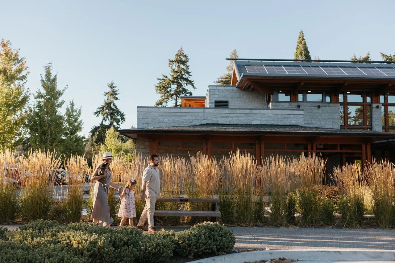 Contemporary eco-friendly Gorge Pavilion amid tall grasses with a family strolling by.