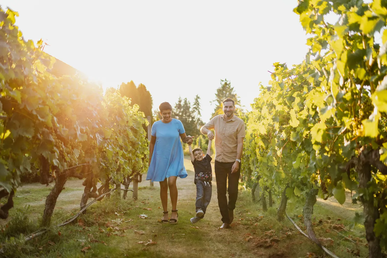 Family enjoying a sunny stroll through vineyard rows
