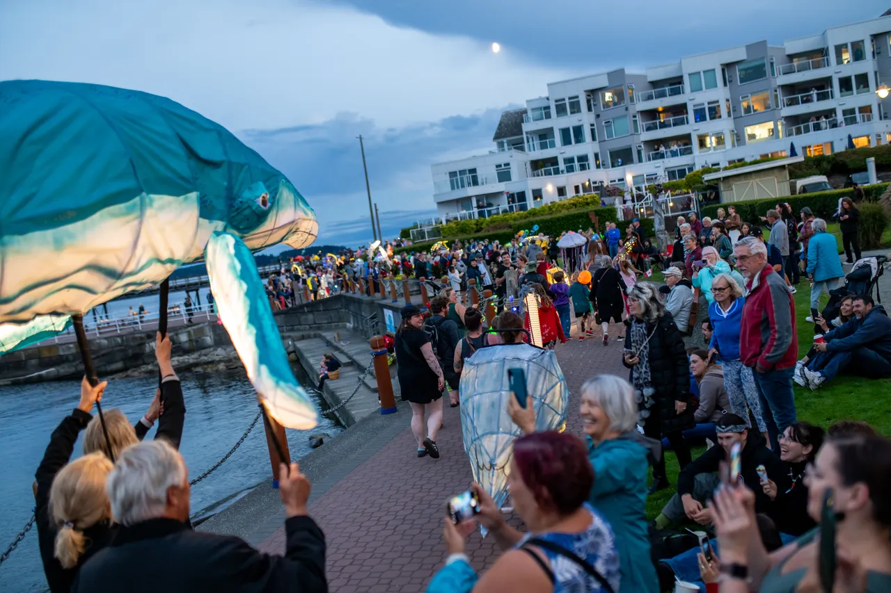 Whale Lantern Leads Parade Along Waterfront Promenade as Crowds Watch at Dusk