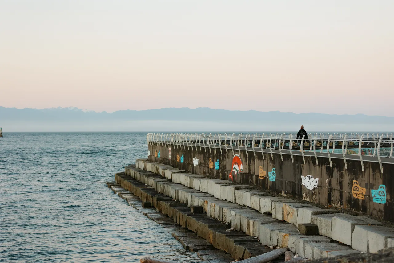 Evening stroll along a painted ocean breakwater walkway