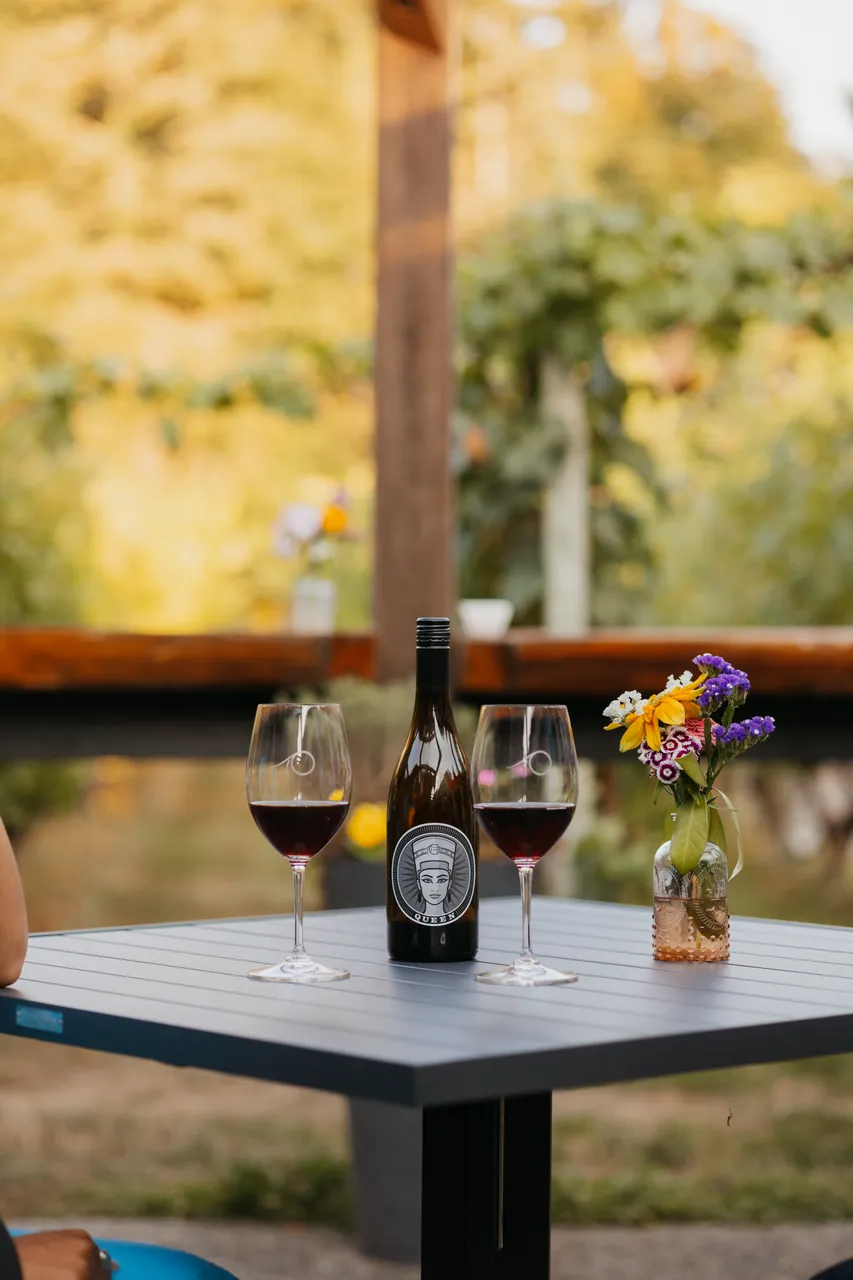Afternoon wine and flowers on sunny patio table