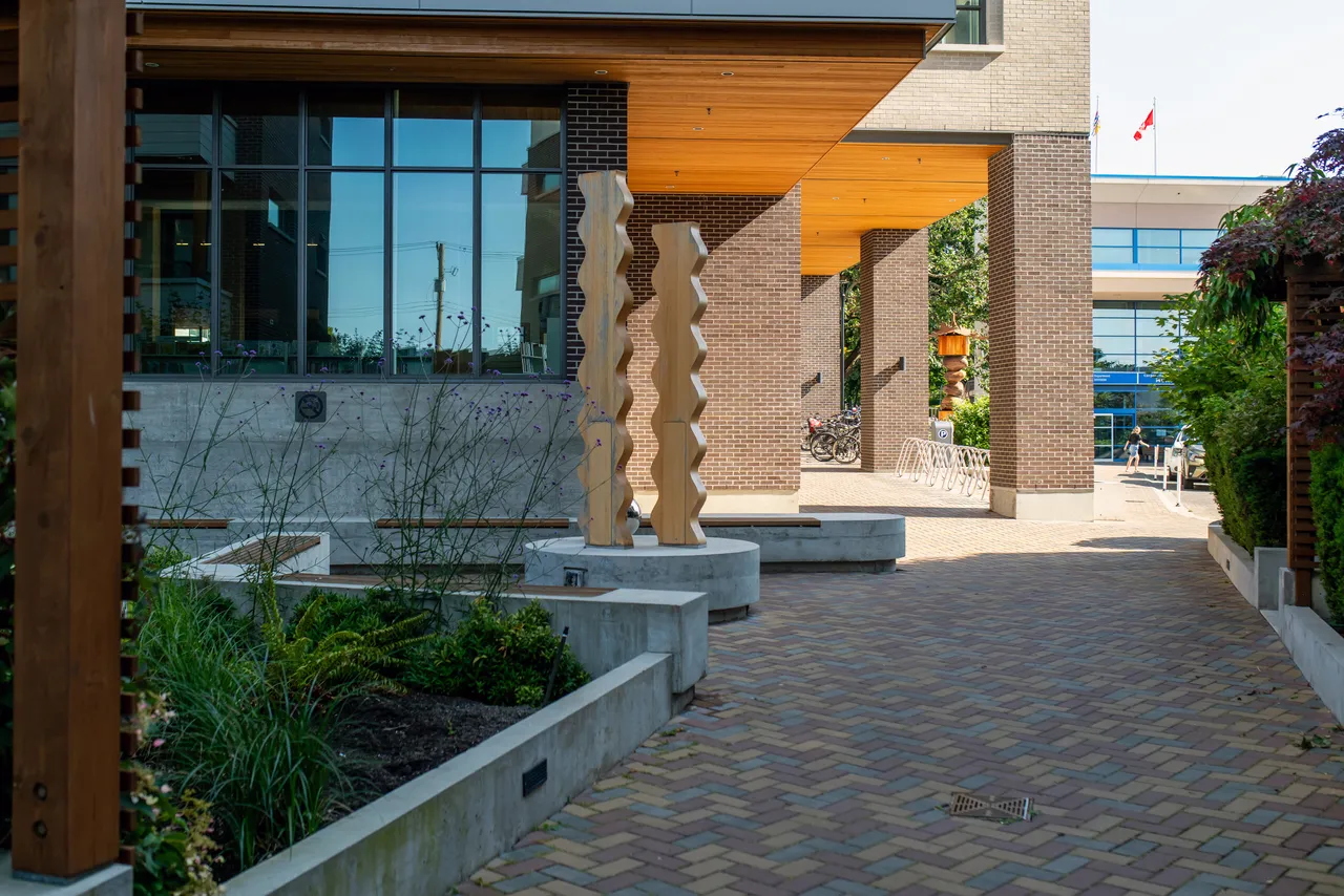 Brick Corridor near Building with Wooden Art during Summer