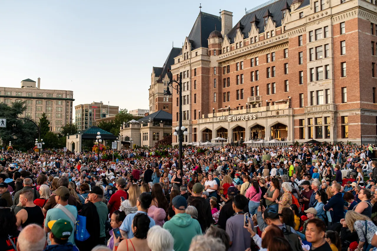 Packed Crowd Gathered in Front of the Empress Hotel at Dusk