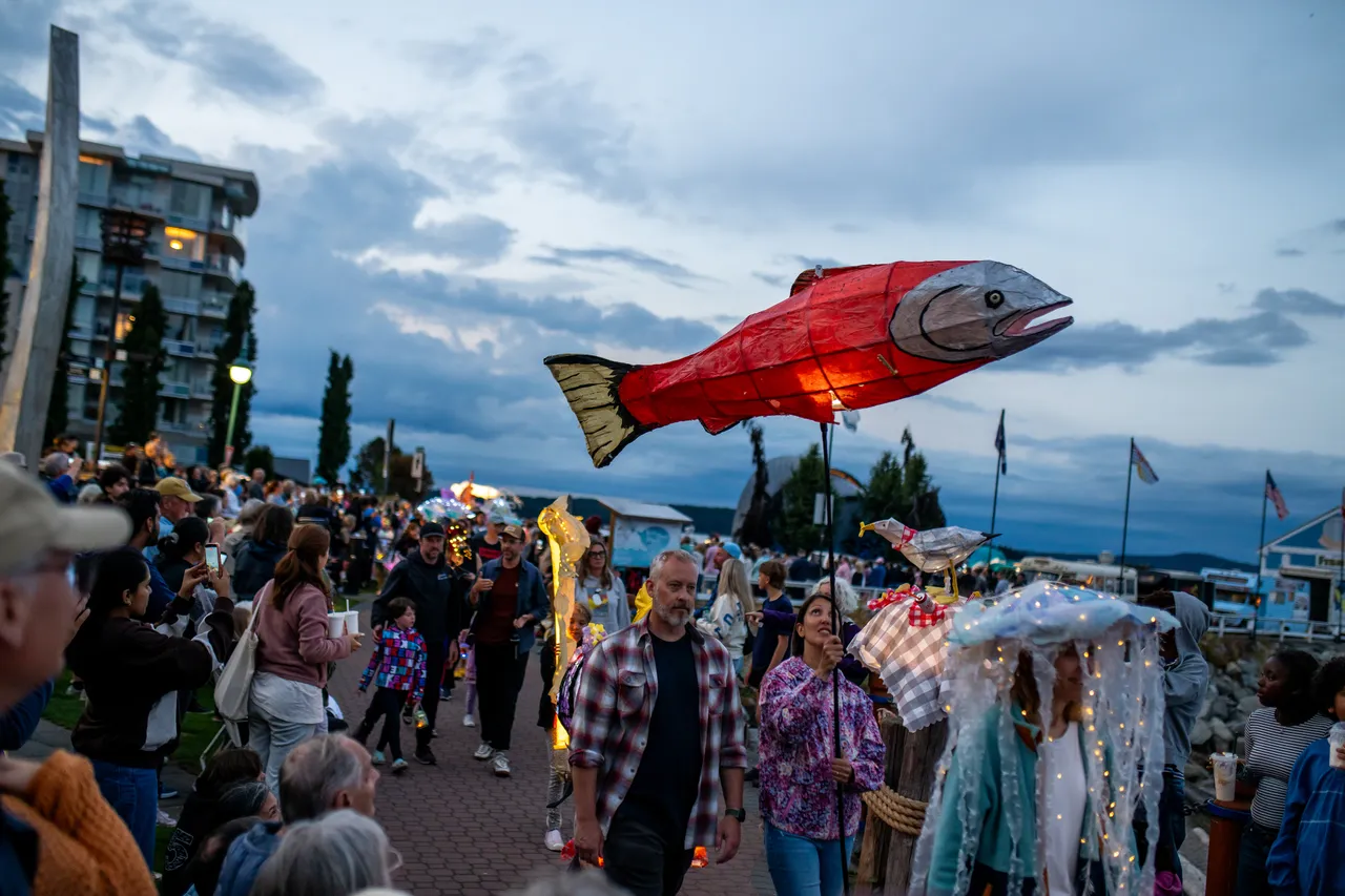 Giant Salmon Lantern Carried Above Crowd at Waterfront Evening Parade