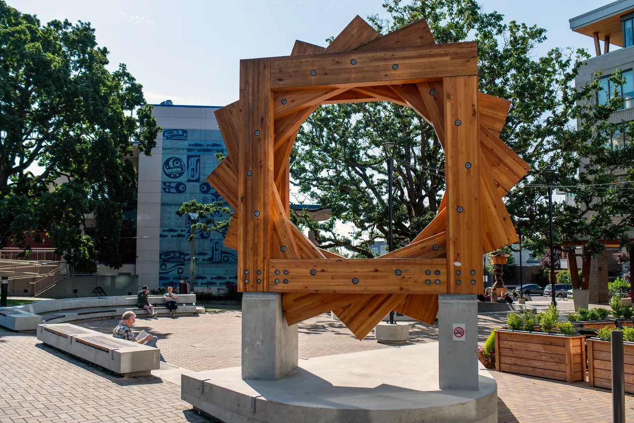 Wooden Art in Public Gathering Area near Trees and Benches