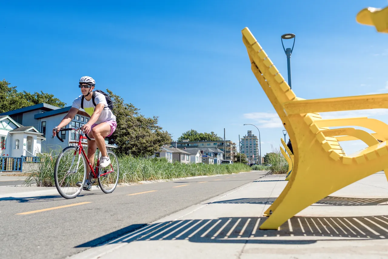 Man cycling by lounge chairs - 1