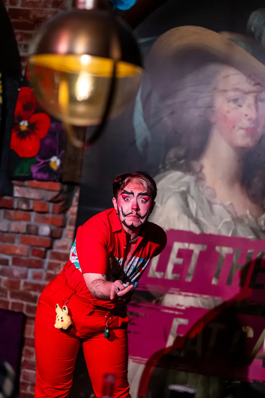 Performer in Red on Stage Looking at Camera with Light in Foreground