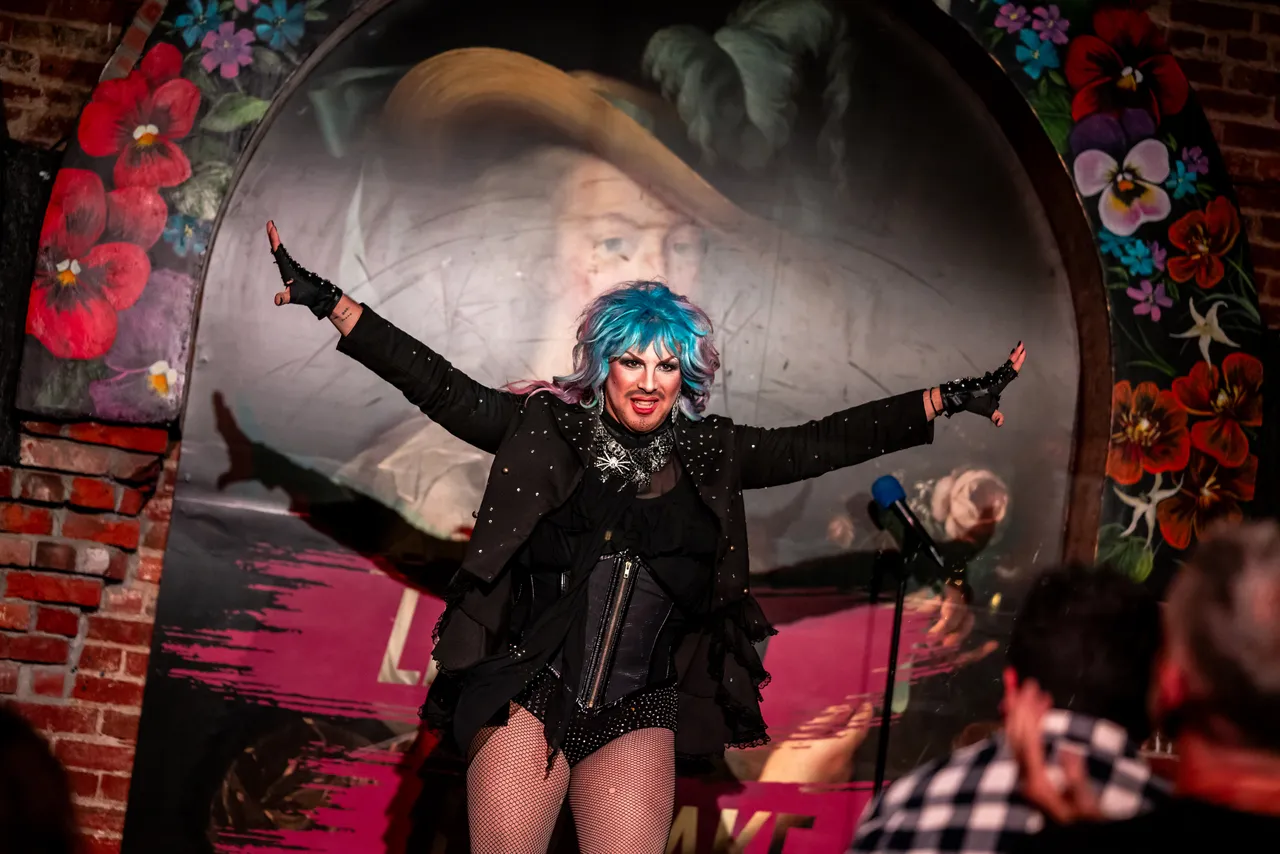 Performer with Blue Hair and Flower Border in Background