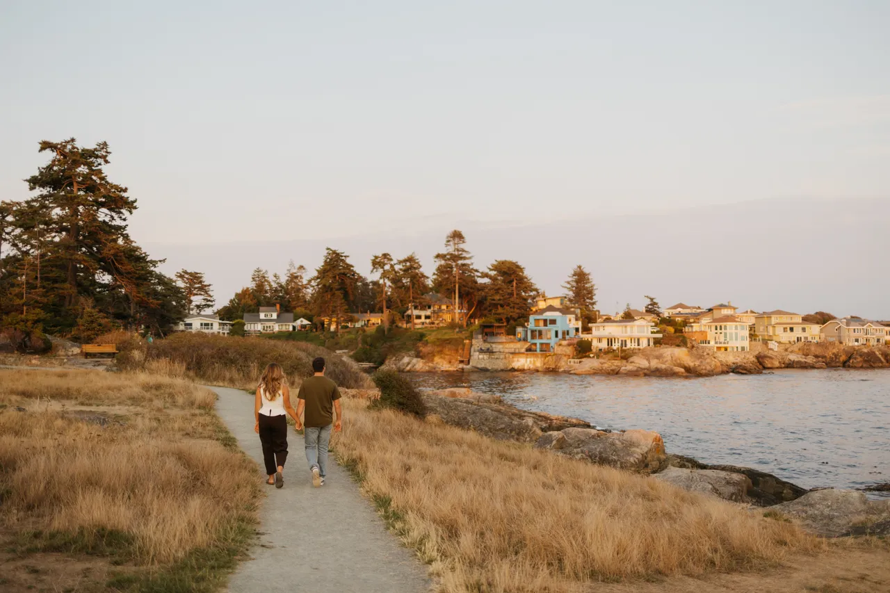Couple walking seaside path at golden evening hour