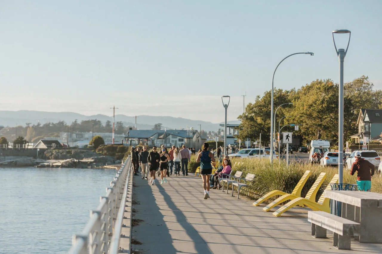 People running and walking by ocean 