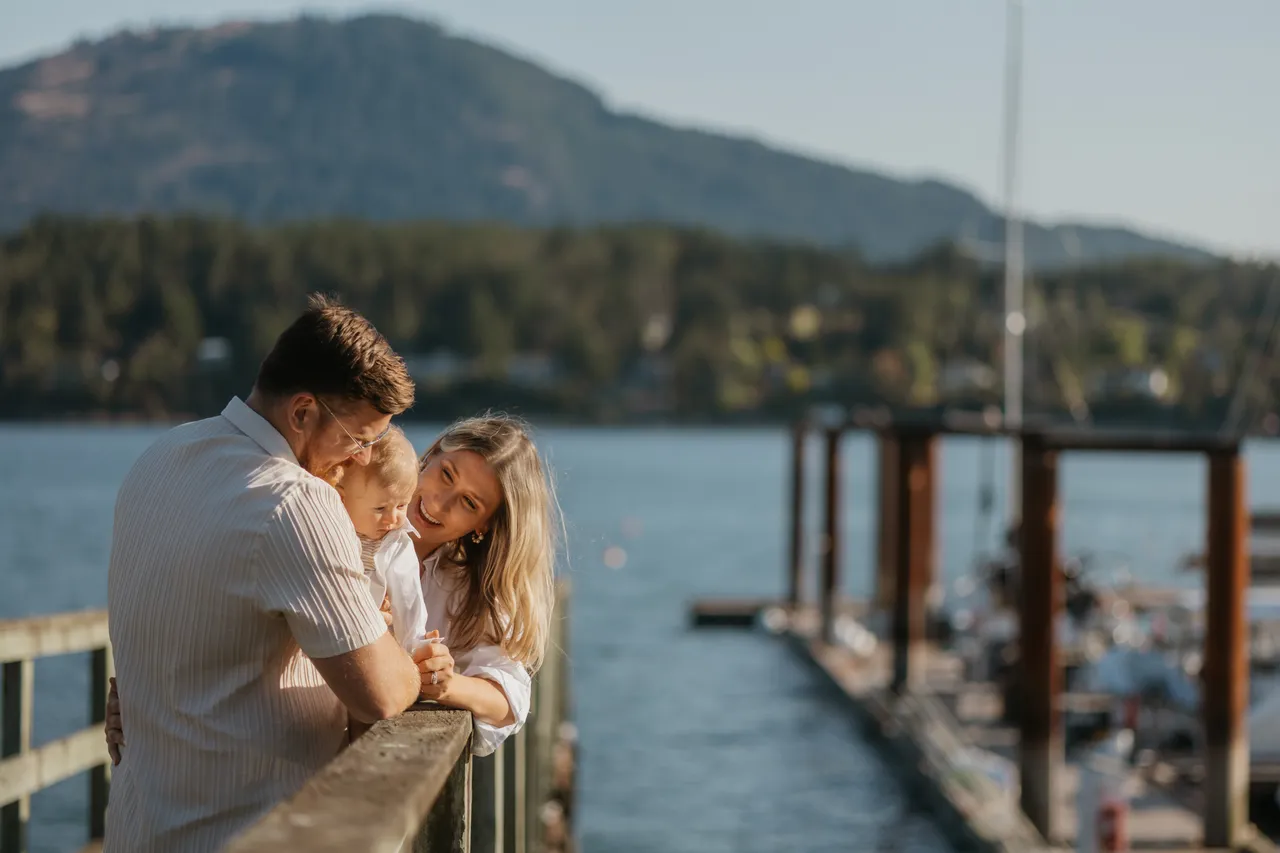 Family enjoying a peaceful moment by the water with mountains in background