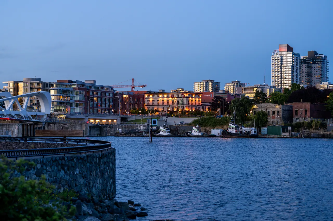 Victoria Harbour with Tall Buildings and Bridge at Dusk