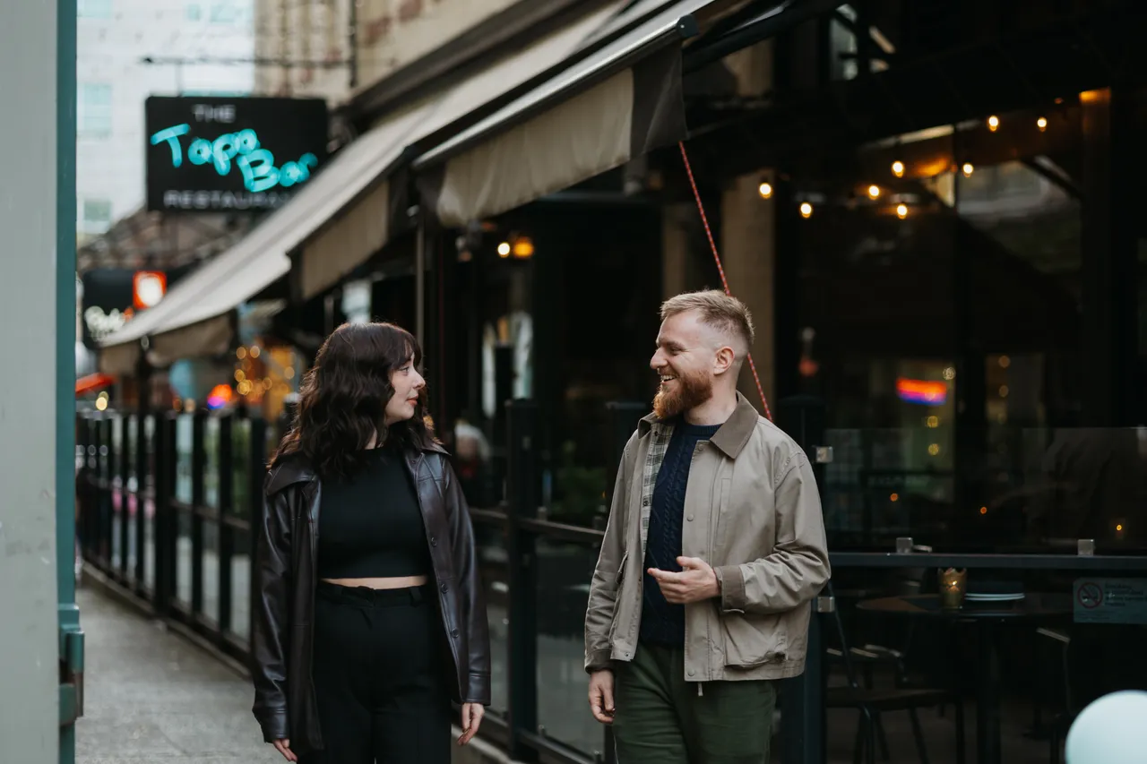 Couple walking by restaurant patio - 1 - Trounce Alley - Victoria