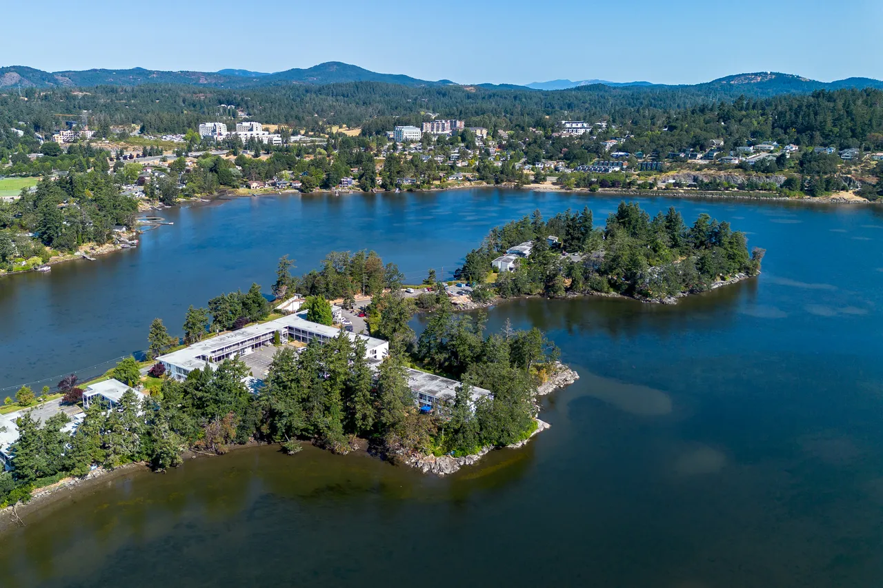 Aerial View with Square Building, Ocean and Trees in Background