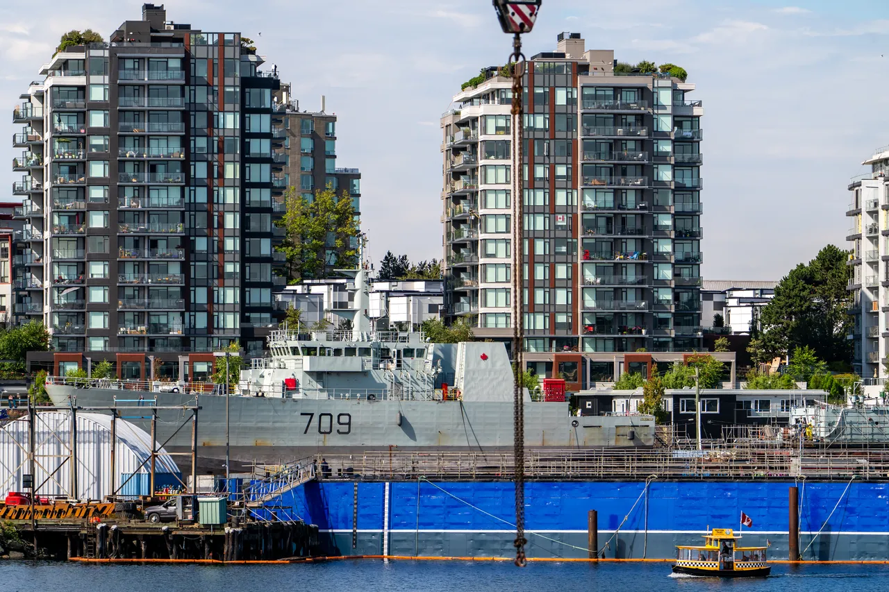 Naval Vessel in Refit Among Waterfront High-Rises at Harbour