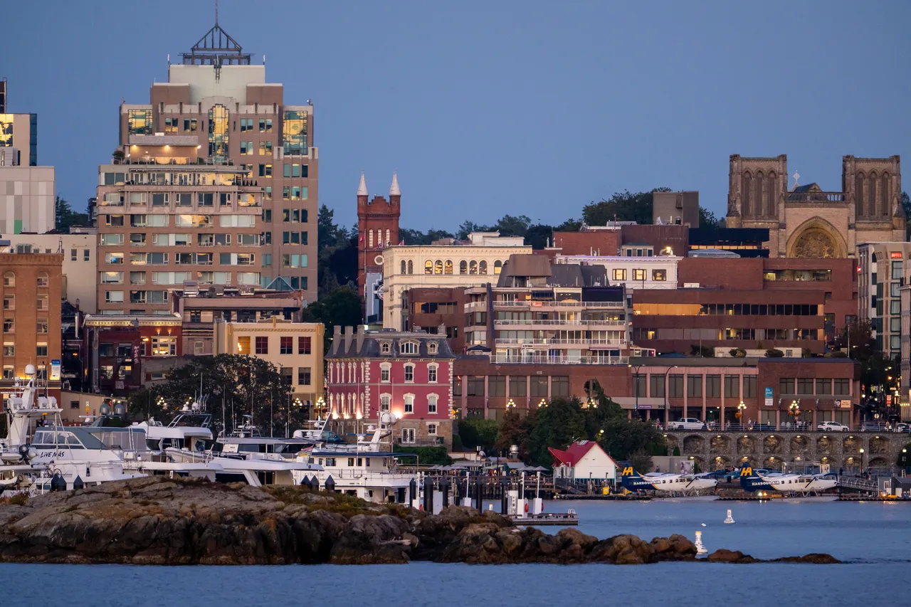 Boats and Planes on Victoria Harbour with Tall Buildings at Dusk