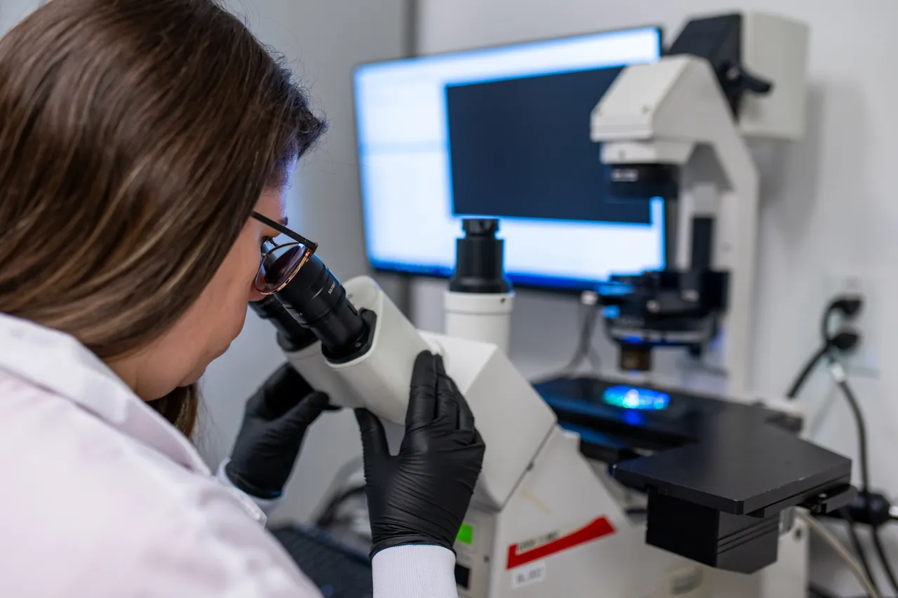 Woman looking through microscope - Karolina - 2