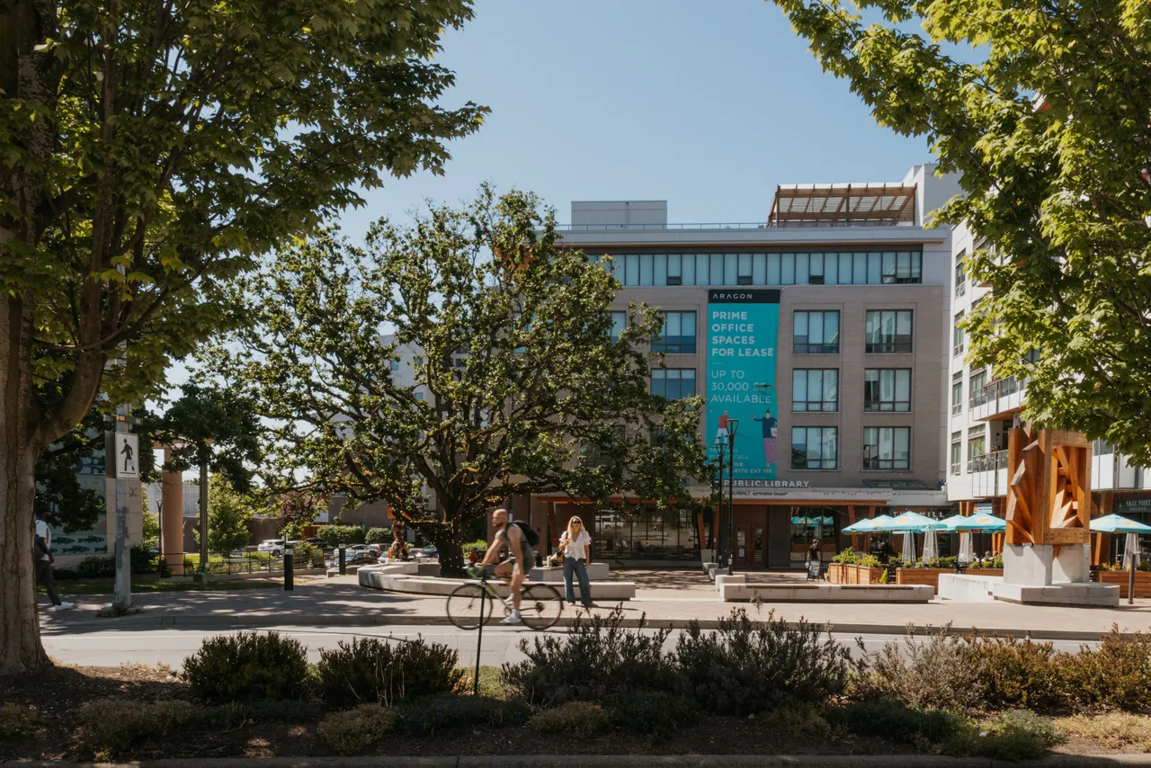 Person Biking near the Greater Victoria Public Library with Trees Around