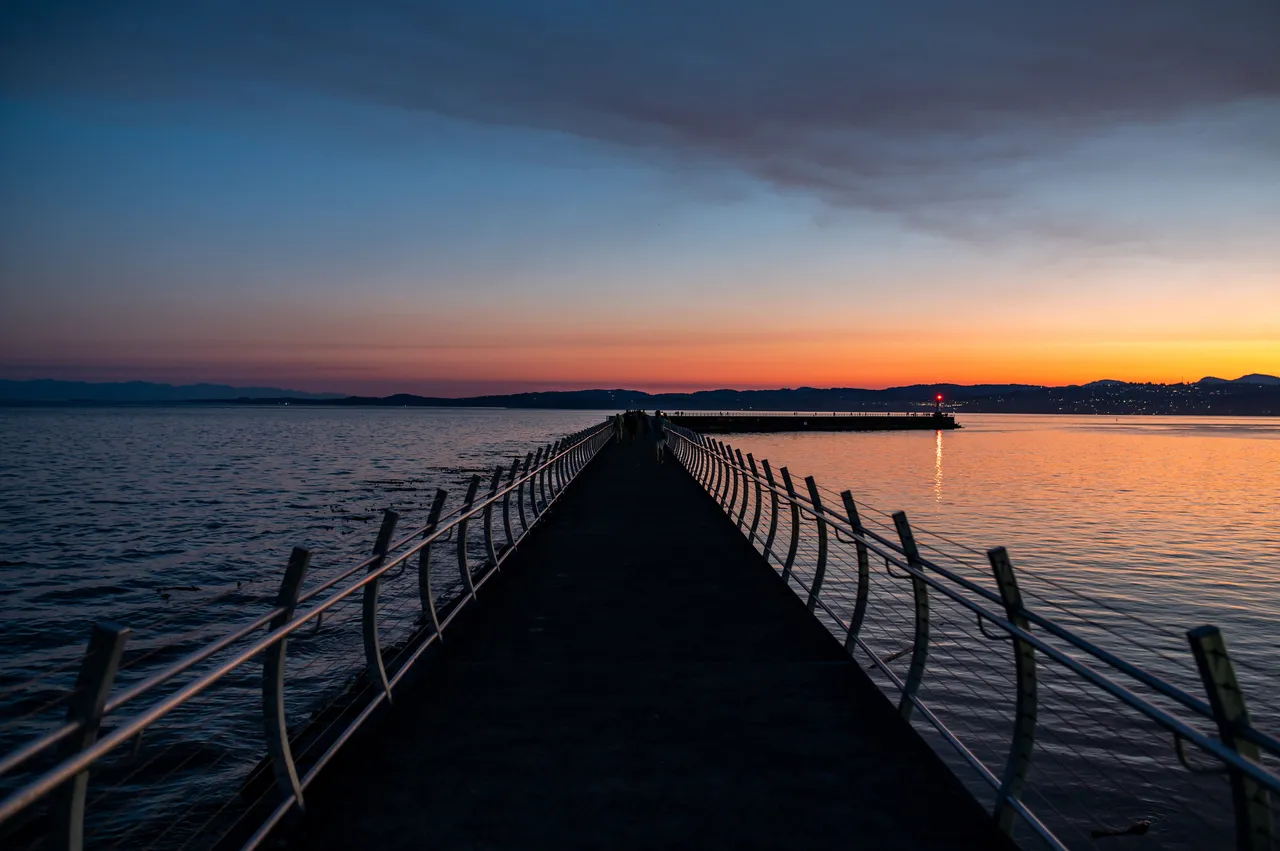 Ogden Point Breakwater at Night with Orange Skyline in Background