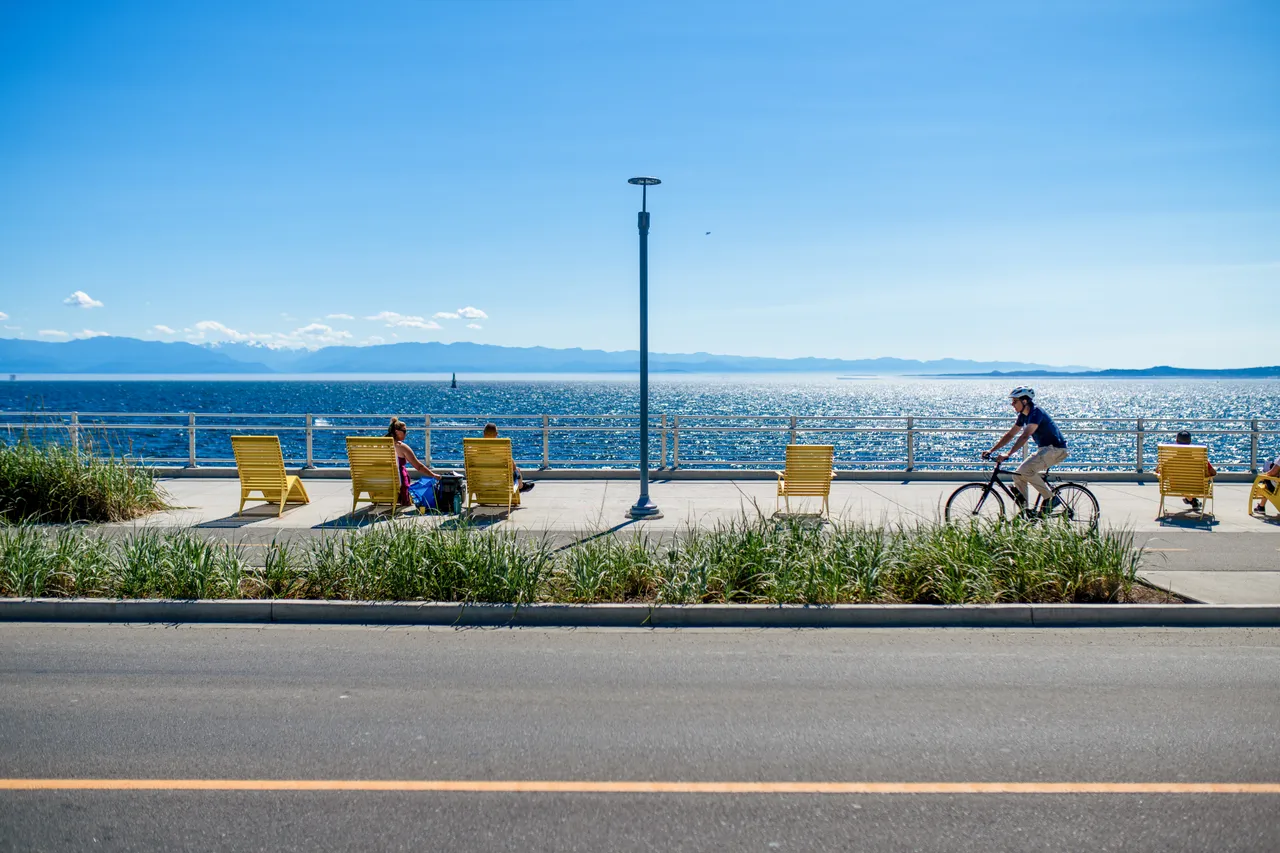 Man cycling by lounge chairs - 2