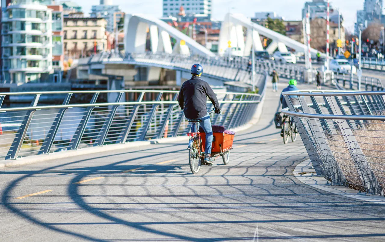 Men cycling across bridge - 2 - Victoria