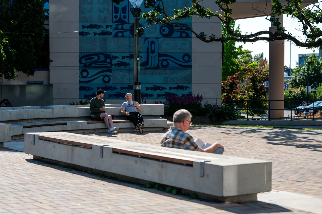 People on Concrete Benches with Art in Background