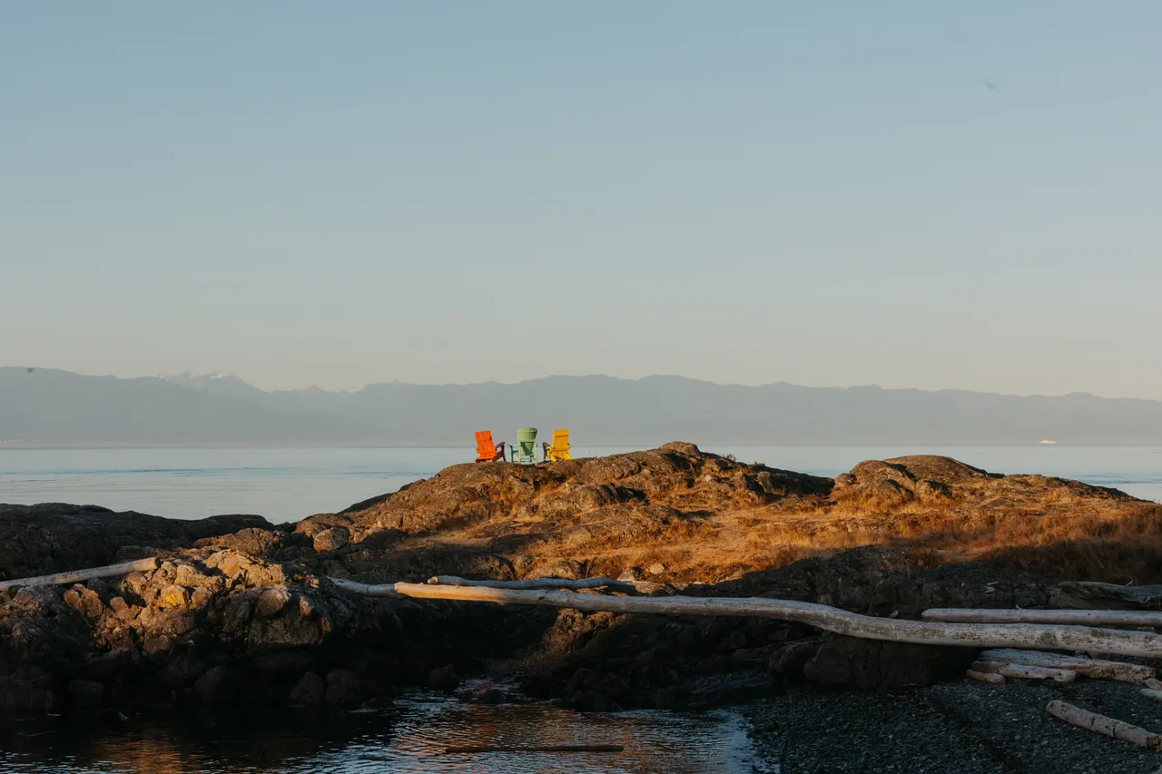 Peaceful coastal viewpoint with calm waters and rocky shore and mountains in background