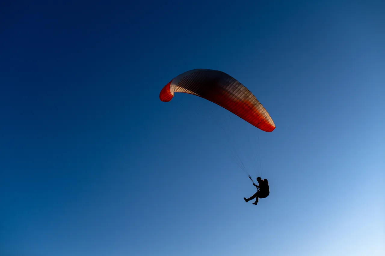 Person Paragliding on Dallas Road with Sky in Background