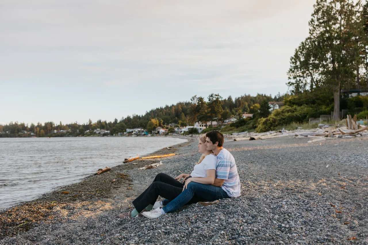 Couple relaxing on a peaceful coastal pebble beach