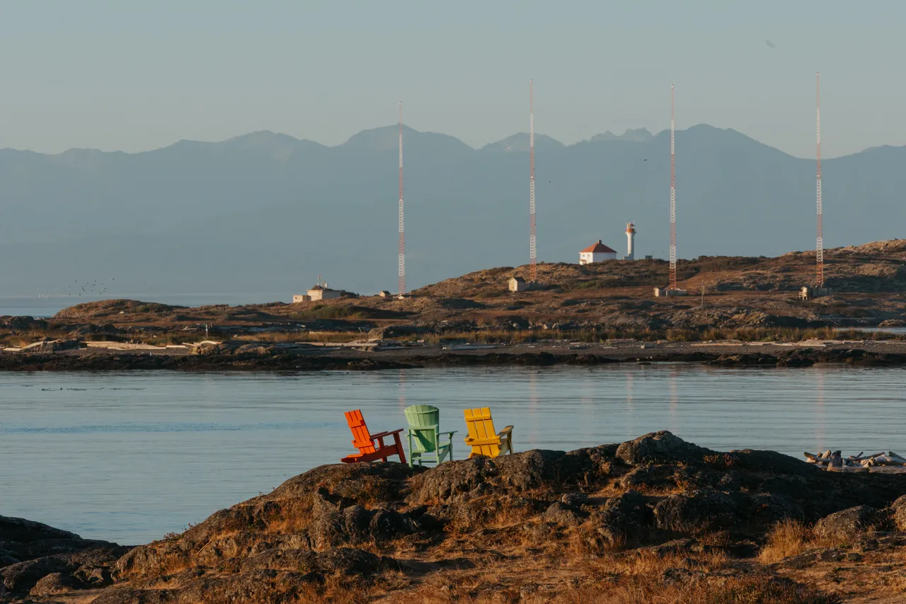 Colourful chairs by the coastal lookout with mountains in background