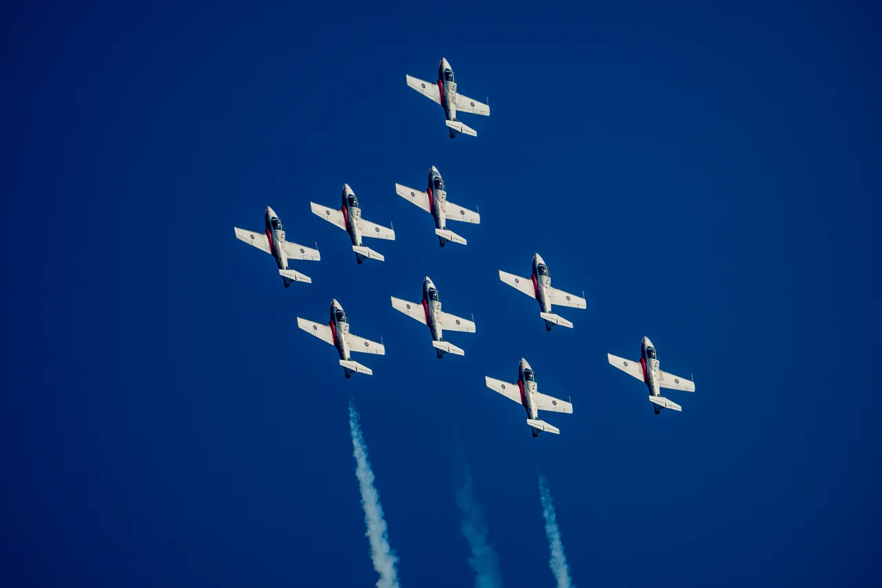 Snowbirds Nine-Jet Diamond Formation Climbing in Deep Blue Sky