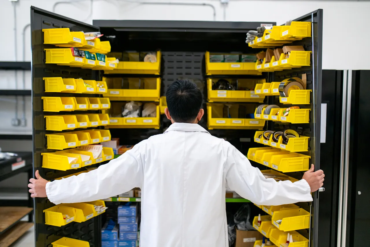 Person in Lab Coat Opening Storage