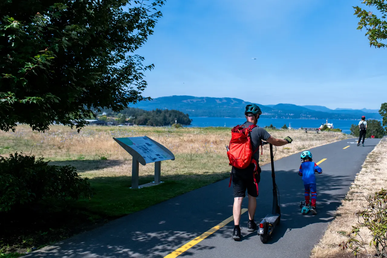 Parent and Child along Walkway with Scoot during Summer