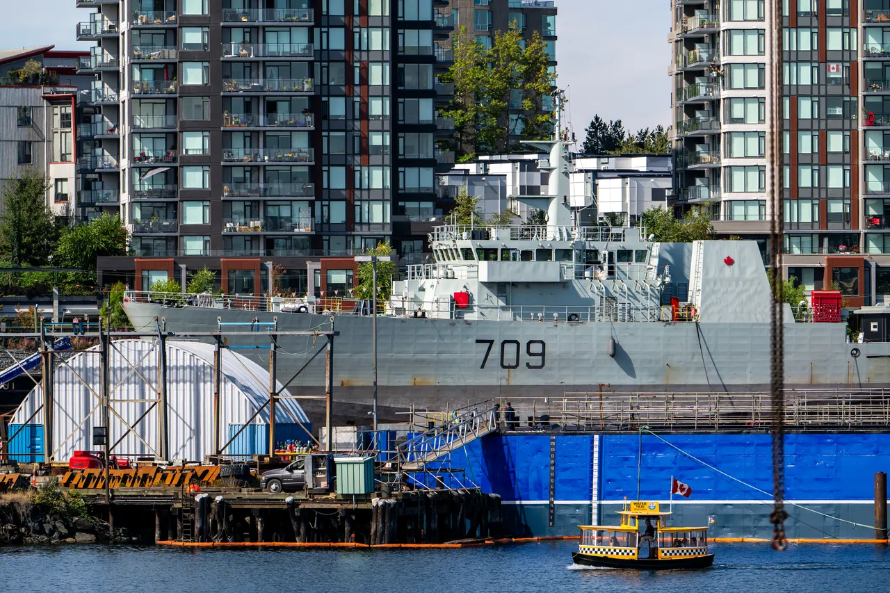 Victoria Harbour Ferry Passing a Docked Warship at the Shipyard