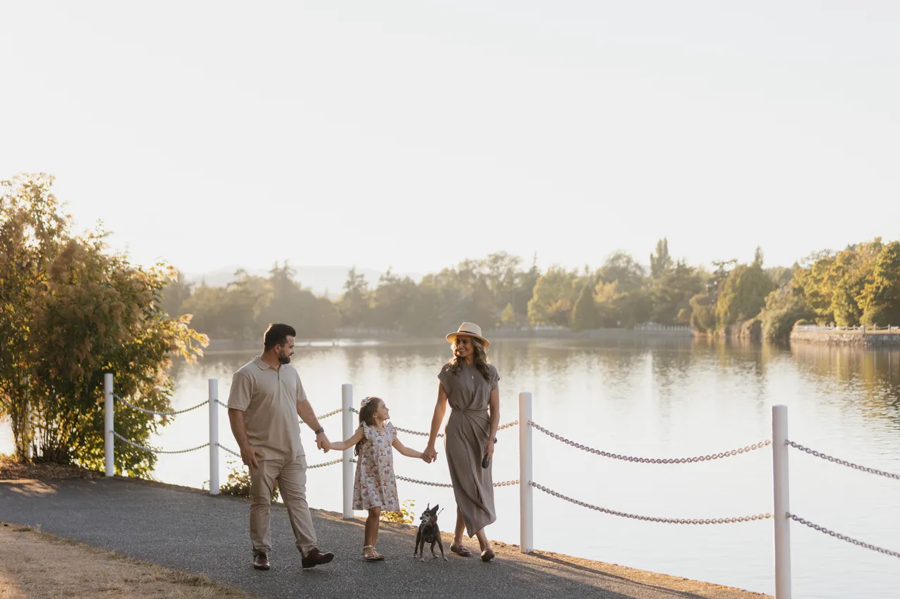 Family walking along path on a sunny morning near a body of water