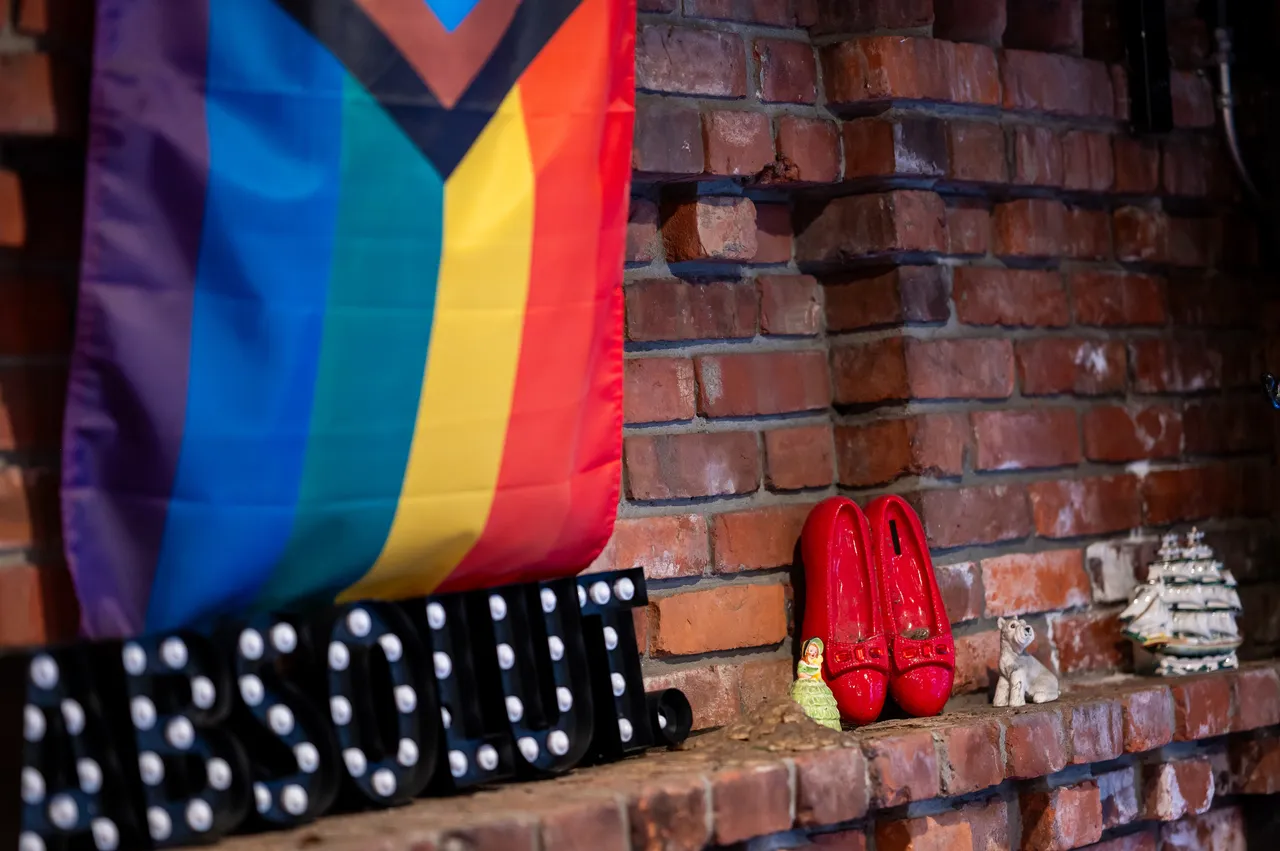 Pride Flag with Red Slippers on a Brick Wall