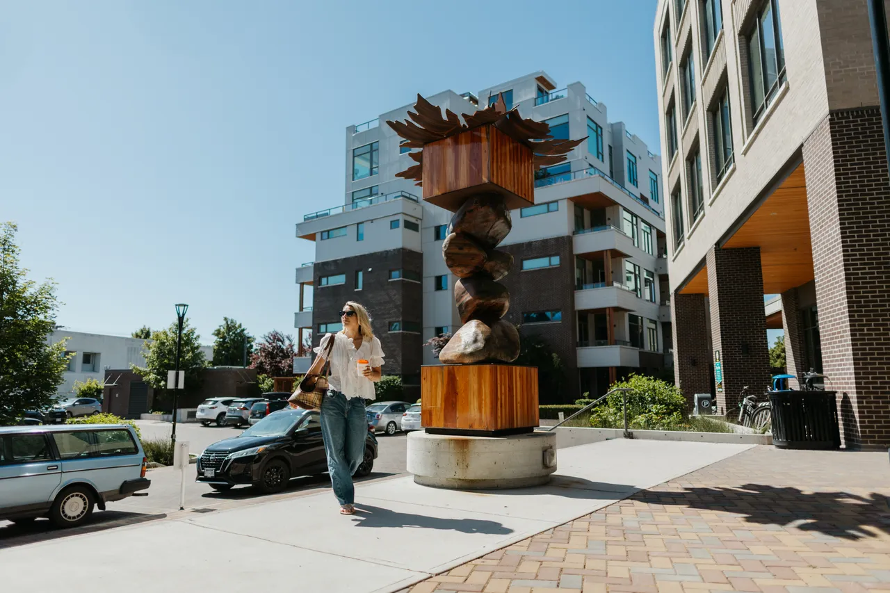 Person and Wooden Statue by Apartment Buildings in Esquimalt