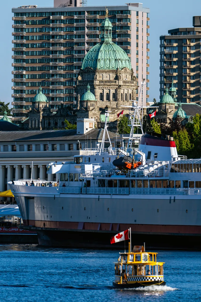 Parliament Buildings during the Day with Boat nearby and Apartment Buildings in Background