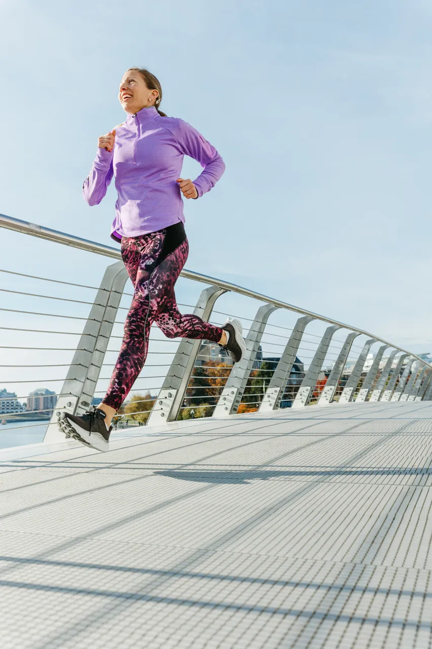 Woman running across bridge - 1