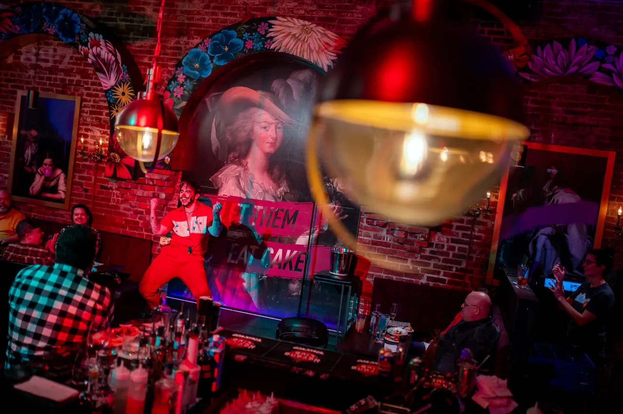 Performer with Red Lighting and Hanging Lights in Foreground