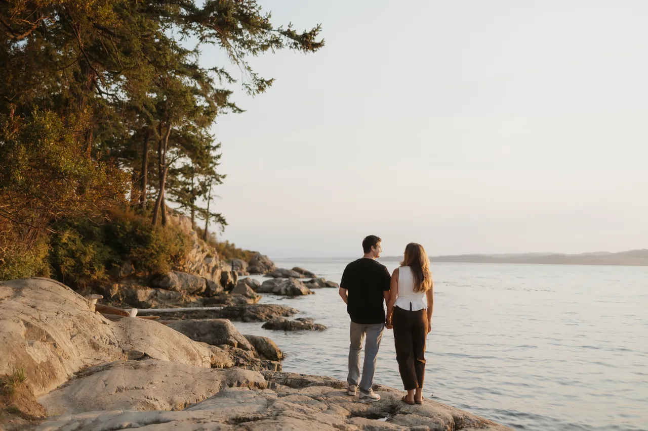 Couple walking along a rocky coastal shoreline