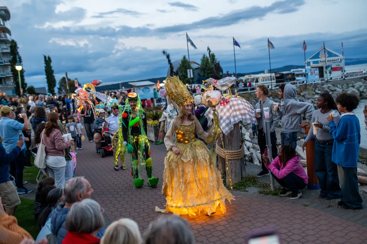 Performer in Glowing Golden Kelp Costume Leads Waterfront Lantern Parade