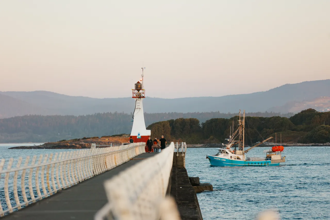 Evening walk along a coastal pier with fishing boat